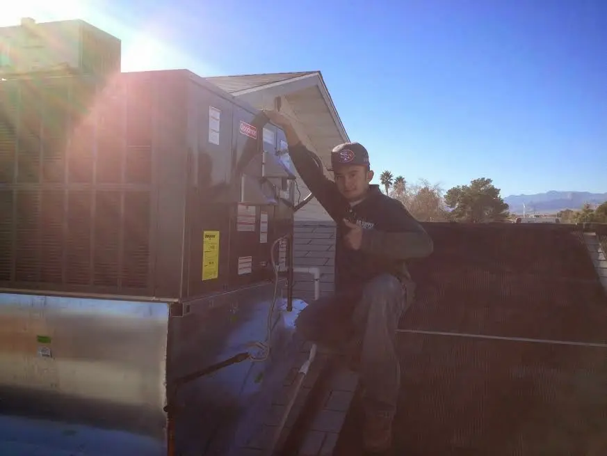 HVAC technician performing Air Duct Cleaning on a rooftop unit in Peru